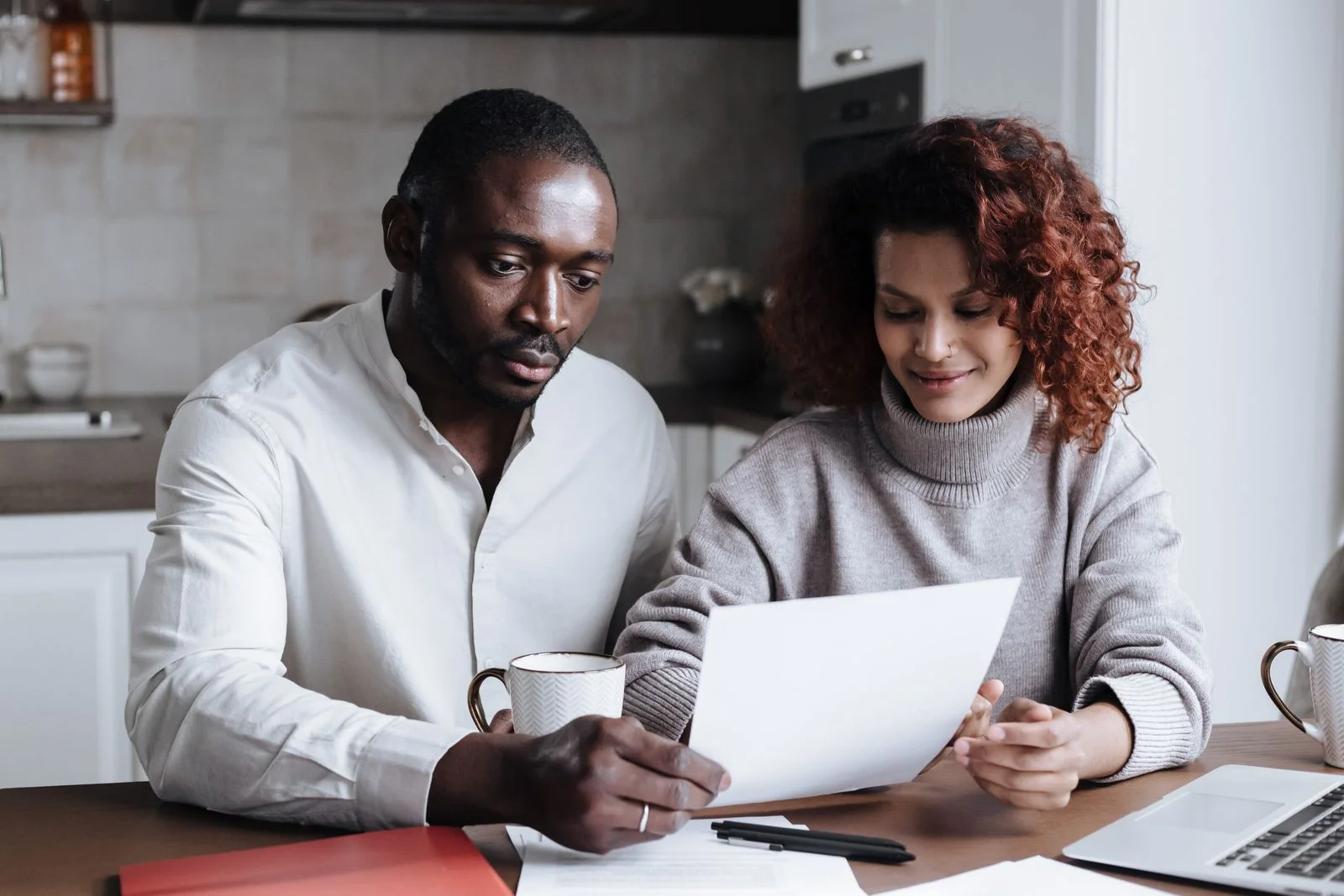 A couple working through their finances together at the kitchen table