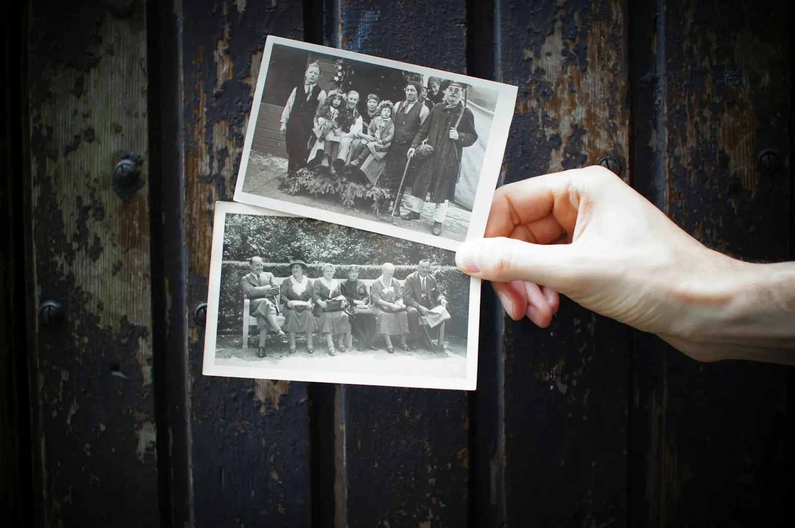Hands holding a set of old family photographs