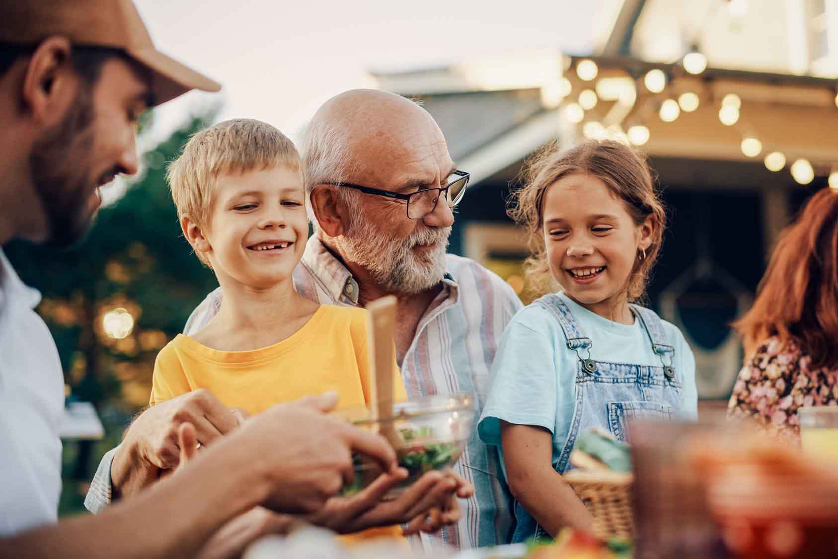 Happy grandfather talking and having fun with grandchildren